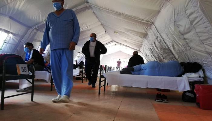 Pacientes a su paso por las carpas militares instaladas afuera del hospital del IESS del sur de Quito.