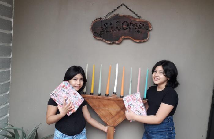 Niñas recibiendo regalos por Janucá.