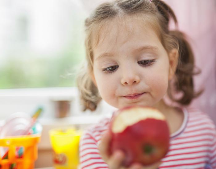 Niña saboreando una manzana