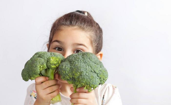 Niña cosumiendo vegetales