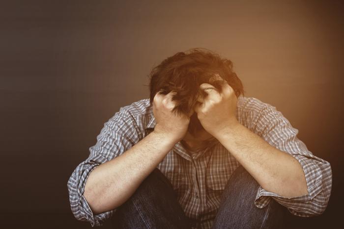 sad-man-holding-head-with-hand