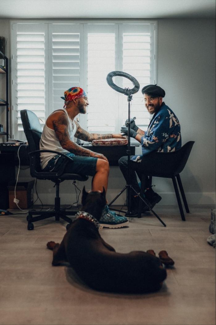 El Topo mientras realiza un tatuaje a Maluma