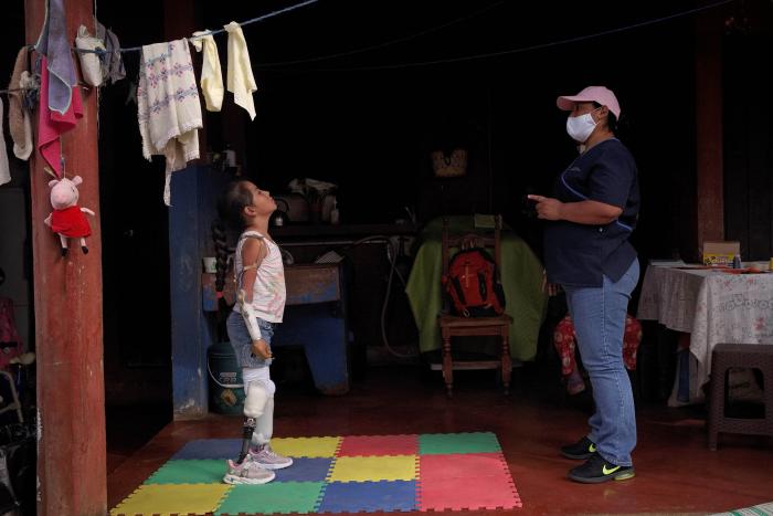 Cárol, de 8 años y paciente beneficiada por el programa de rehabilitación de la asociación Rang of Motion Project (ROMP), realiza terapia con su monitora Zayra para mejor el uso de sus prótesis, el 27 de abril de 2022, en Ciudad de Guatemala (Guatemala).