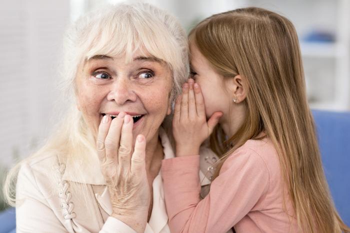 little-girl-telling-secret-to-grandma