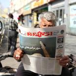 un hombre lee el diario iraní con el titular