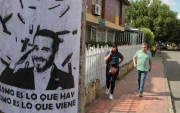 Personas caminan junto a un cartel alusivo al ultraderechista Abelardo de la Espriella.