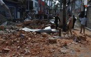 Personas caminan frente a una edificación afectada tras un fuerte temblor este lunes, en Manizales (Colombia)