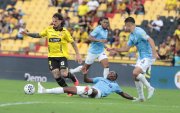 Darío Benedetto (i) es arrinconado por jugadores de la Católica.