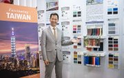 Augusto Liao, representante gubernamental de la Oficina Comercial de Taipéi en Ecuador, junto a las muestras y catálogos expuestos en su stand.