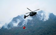 Fotografía cedida por el Cuerpo de Bomberos de Cuenca de un helicóptero combatiendo un incendio forestal en el Parque Nacional Cajas, en Cuenca (Ecuador).