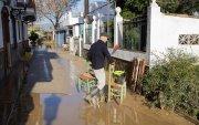 Un vecino en el sur de España, limpia de lodo y barro el interior de su vivienda ante la crecida del río Guadalhorce y las precipitaciones intensas tras decretarse la alerta roja.