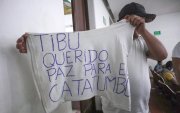 Un hombre desplazado por la violencia mostrando una camiseta con una nota escrita pidiendo paz para el Catatumbo en Cúcuta (Colombia).
