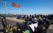 Policías peruanos (d) y chilenos vigilan a cientos de migrantes varados en la frontera, en Arica (Chile).