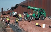 Obreros estadounidenses construyen un muro fronterizo, entre El Paso y Ciudad Juárez (México).