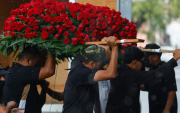 Integrantes del cortejo fúnebre trasladan un arreglo de rosas rojas durante el sepelio de ‘El Mencho’, en medio de un fuerte operativo en Jalisco.