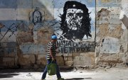 Una persona camina frente a un mural con la imagen de Ernesto 'Che' Guevara este jueves, en una calle de La Habana (Cuba).