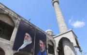 Un hombre limpia una valla publicitaria del nuevo líder supremo de Irán, el ayatolá Mojtaba Khamenei (derecha), y al difunto ayatolá Ruhollah Khomeini (izquierda),  en Cachemira, India, el 24 de marzo de 2026.