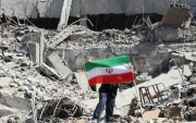 “Un ciudadano sostiene la bandera de Irán en medio de los escombros tras recientes ataques.