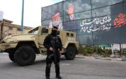 Un miembro de las fuerzas de seguridad iraníes monta guardia junto a una pancarta en honor al exlíder supremo iraní Ali Khamenei, en Teherán, Irán, el 30 de marzo de 2026.