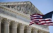 Foto que muestra una bandera estadounidense ondeando frente a la Corte Suprema de Estados Unidos en Washington D. C.