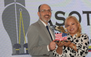 Erik Martini recibe un presente de manos de Nery Merejildo, presidenta de la AMCHAM.