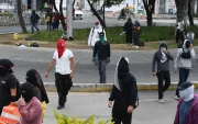Encapuchados caminan durante una manifestación el 7 de abril de 2026, afuera de la Universidad de San Carlos de Guatemala (Guatemala).