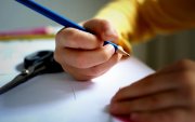 Imagen referencial de un niño escribiendo.