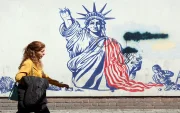 Una mujer camina junto a un mural antiestadounidense cerca de la antigua Embajada de EE. UU. en Teherán.