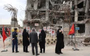 Varias personas se reúnen para observar fotografías de los fallecidos en un ataque aéreo estadounidense-israelí contra un edificio residencial, expuestas frente al mismo edificio que fue alcanzado en Teherán, Irán, el 13 de abril de 2026.