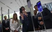 El presidente del Gobierno español, Pedro Sánchez), se toma una foto con un teléfono inteligente Xiaomi en presencia de su esposa, Begoña Gómez, en Pekín, el 13 de abril de 2026.