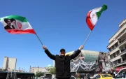 Un hombre ondea este miércoles 22 de abril de 2026, banderas iraníes en Teherán.