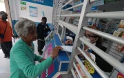 Una mujer de la tercera edad muestra una receta médica para comprar fármacos.