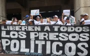 Personas sostienen carteles como parte de una manifestación para denunciar la situación de los presos políticos en cárceles de Venezuela este lunes, en Caracas (Venezuela).