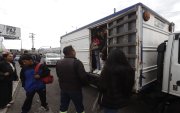 Personas abordan vehículos no convencionales en medio de la crisis del transporte urbano.