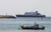 El crucero holandés MV Hondius (al fondo) está anclado frente a la costa de la ciudad de Praia, en la isla de Santiago, Cabo Verde, el 4 de mayo de 2026.