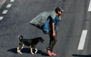 Un hombre camina junto a un perro por una calle del bulevar Fuerzas Armadas este jueves, en Tegucigalpa (Honduras).