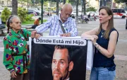Familiares de Víctor Hugo Quero Navas, quien fue detenido hace más de un año en Venezuela, sostienen un cartel.