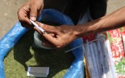 Un vendedor enrolla hojas de molokhia, también conocidas como malva de yute, que normalmente se usan en la cocina, para hacer un cigarrillo el 19 de abril de 2026.