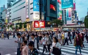 Fotografía de personas transitando un paisaje urbano en Japón.