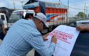 Una autoridad firma un sello que pusieron a una piladora que fue clausurada.