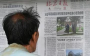 Un hombre lee un periódico en Pekín sobre la visita de Donald Trump a Xi Jinping.