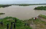 Fotografía de archivo que muestra a personas observando las inundaciones en la localidad de Chanduy en Santa Elena.