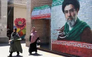 Ciudadanas iraníes pasan junto a una fotografía del líder supremo iraní, el ayatolá Mojtaba Khamenei, en una calle de Teherán, Irán, el 18 de mayo de 2026.