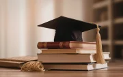 Referencial. El birrete universitario sobre libros simboliza la culminación académica y el registro oficial de títulos en Ecuador.