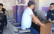 Una persona pregunta a técnicos del SRI sobre beneficios tributarios.