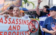 Cubanos en el exilio sostienen un cartel que dice "Asesinos y terroristas" mientras celebran el Día de la República de Cuba en Miami, Florida, EE. UU., el 20 de mayo de 2026.