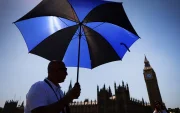 Un hombre se protege del sol con un paraguas en Londres.