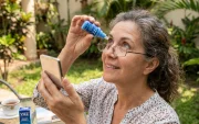 Un usuario aplica gotas VIZZ, el tratamiento que busca reemplazar los lentes de lectura.
