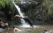 Jóvenes se bañan en una pequeña cascada en el cerro Azul de Guayaquil.