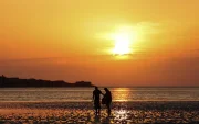 Personas pasean por una playa West Kirkby (Reino Unido). en una jornada calurosa.